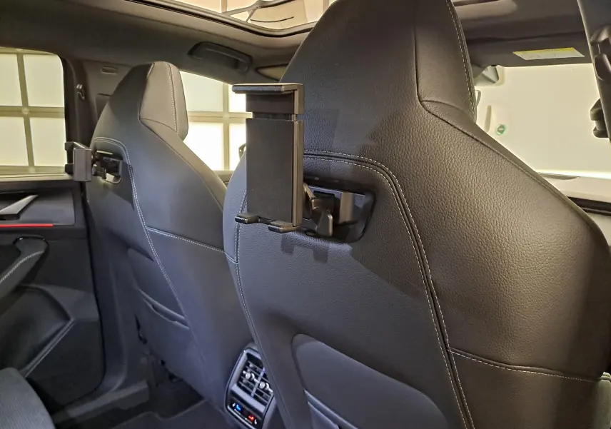 Vue intérieure arrière du Skoda Kodiaq 2025, sièges en cuir noir avec support tablette fixé au dossier côté droit.