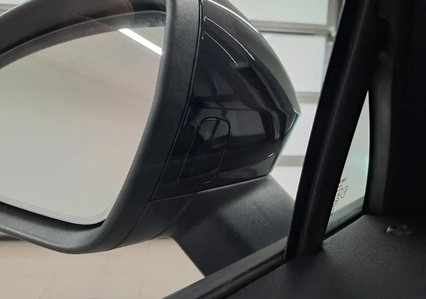 Gros plan sur le rétroviseur côté gauche gris graphite du Skoda Kodiaq 2025 avec capteur intégré.