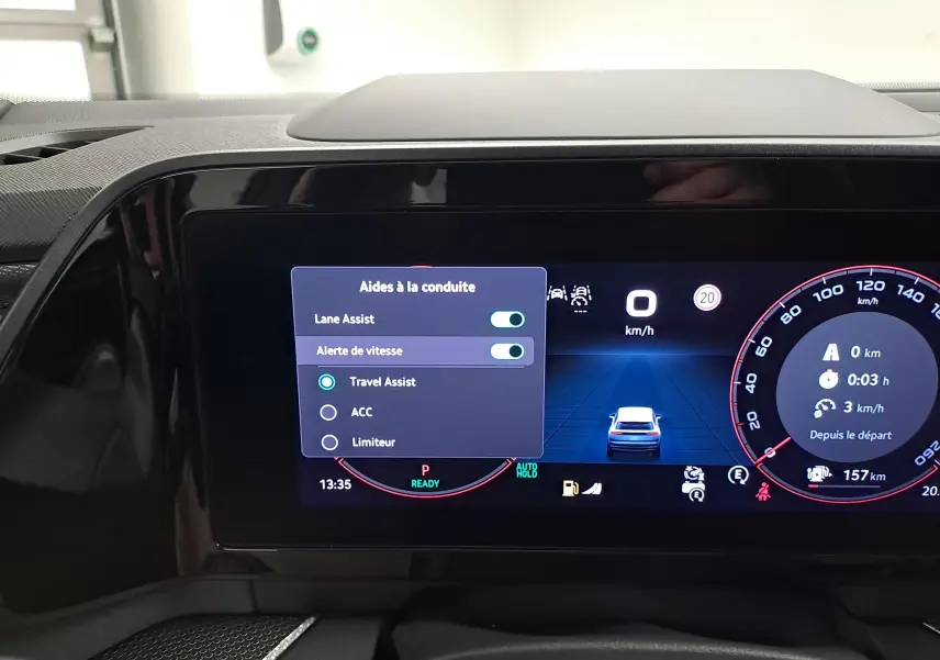 Vue rapprochée de l'écran digital du tableau de bord du Skoda Kodiaq gris graphite, affichant les aides à la conduite activées.