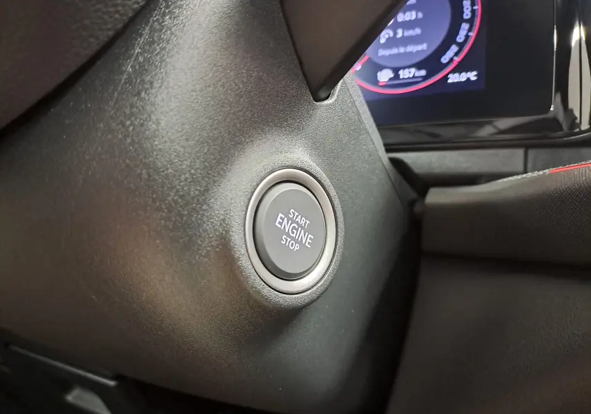 Bouton start/stop moteur en gros plan sur le tableau de bord du Skoda Kodiaq 1.5 TSI PHEV 2025, intérieur noir.