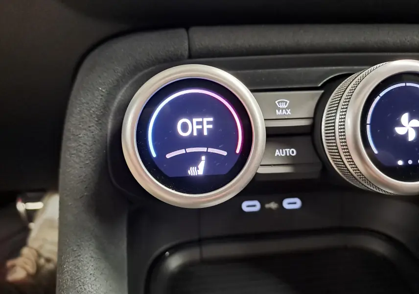 Gros plan sur le bouton de réglage de siège chauffant éteint dans l'habitacle du Skoda Kodiaq gris graphite.