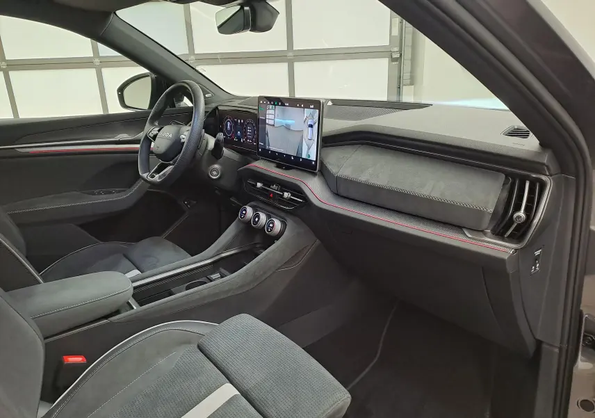Vue intérieure côté conducteur du Skoda Kodiaq 2025 gris graphite, tableau de bord avec écran tactile et volant multifonction.