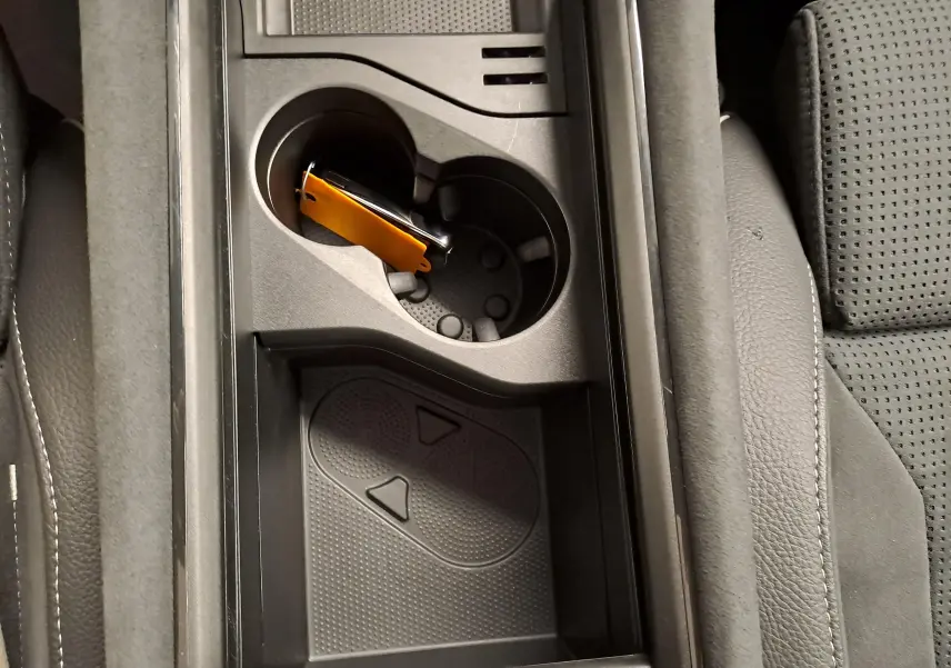 Gros plan sur la console centrale intérieure du Skoda Kodiaq gris graphite, avec porte-gobelets et rangement.