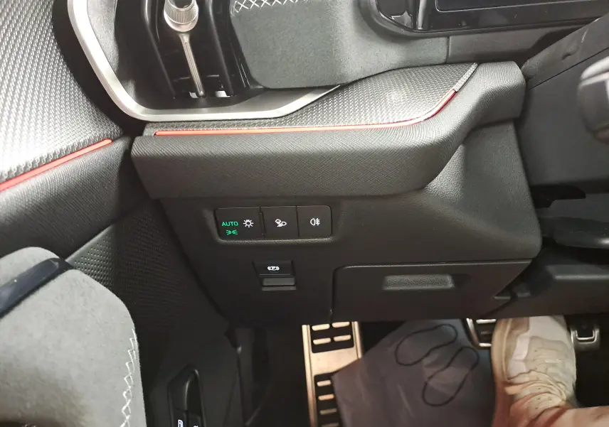 Vue intérieure côté gauche du tableau de bord du Skoda Kodiaq gris graphite, avec commandes d’éclairage et pédalier inox.