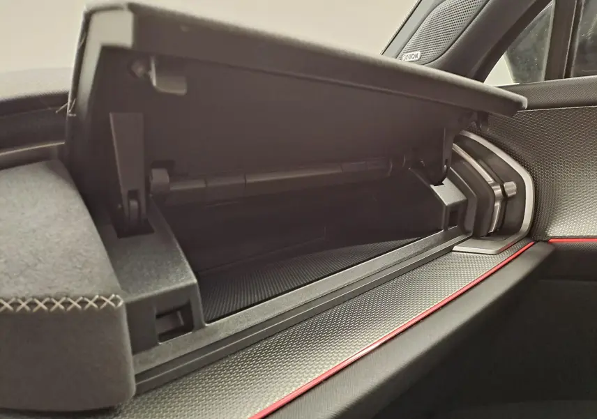 Vue rapprochée de la boîte à gants ouverte côté passager du Skoda Kodiaq gris graphite, avec détails de la planche de bord et surpiqûres.