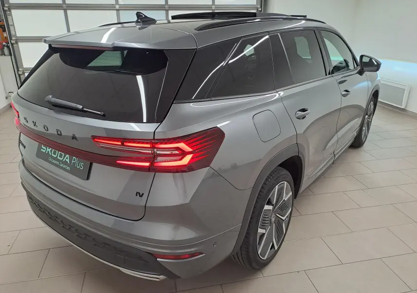 Vue 3/4 arrière droite du Skoda Kodiaq gris graphite avec feux arrière LED allumés et jantes alliage 20 pouces.
