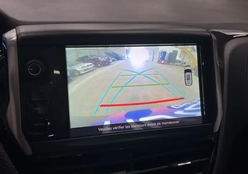 Écran central montrant la caméra de recul d’un Peugeot 2008 noir, vue arrière avec lignes d’aide au stationnement.