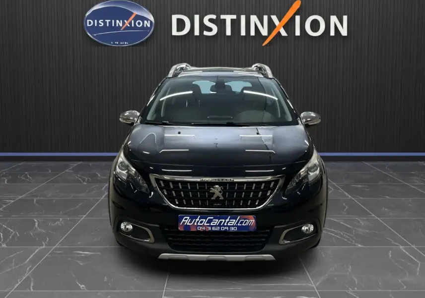 Vue avant d'un Peugeot 2008 Crossway noir, avec calandre chromée et phares allumés dans un showroom.