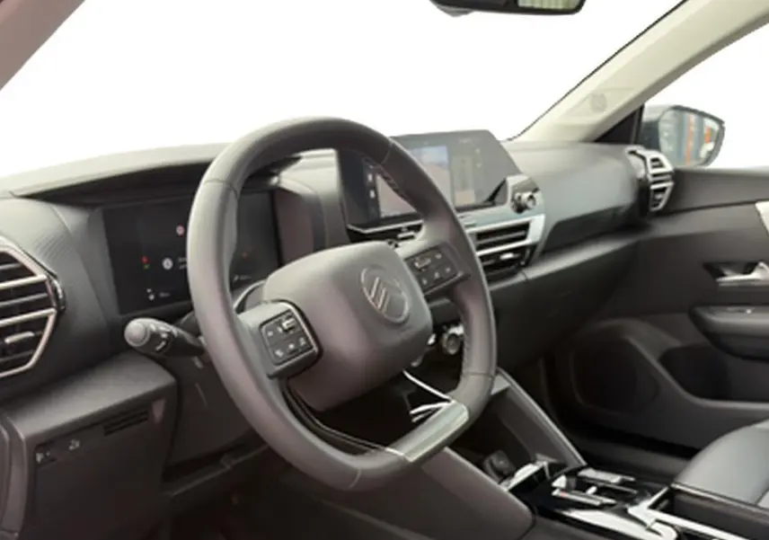 Vue intérieure côté conducteur de la Citroën C4 X 2025, volant cuir et tableau de bord avec écran tactile.