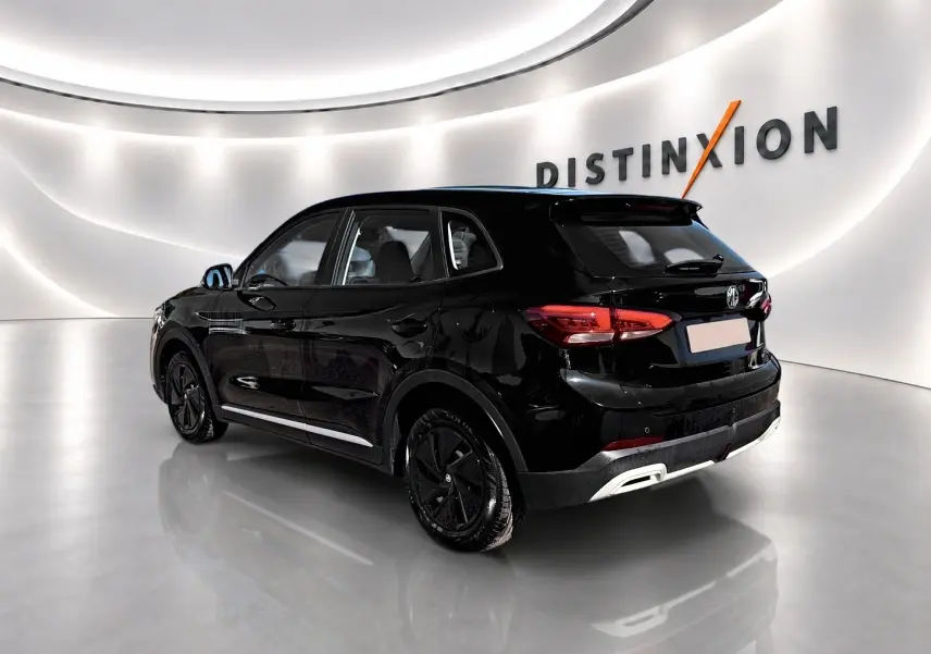 Vue 3/4 arrière droite du MG ZS 1.5 hybrid noir, avec feux LED et jantes noires dans un showroom lumineux.