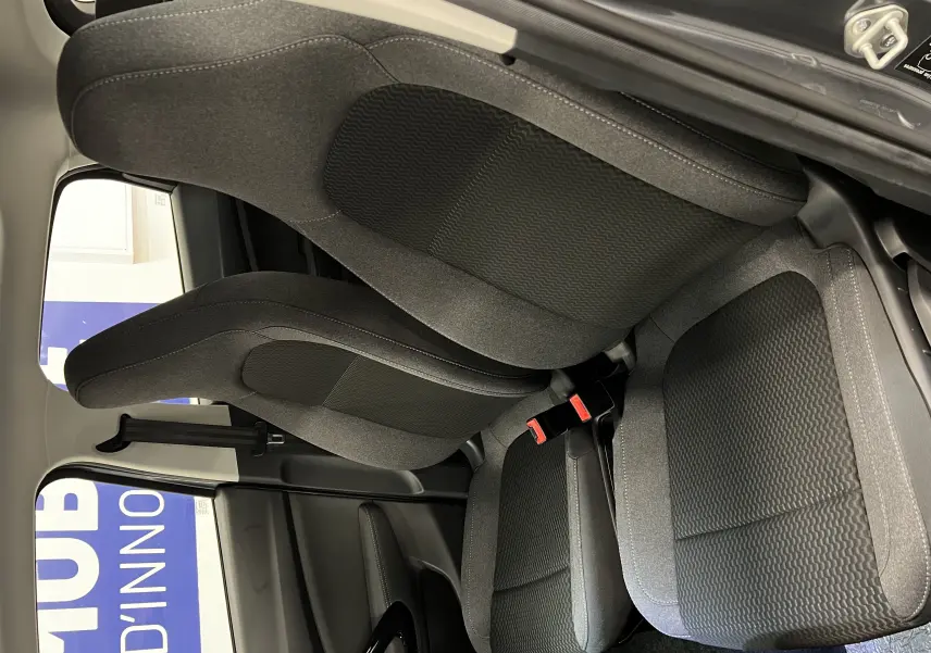 Vue intérieure rapprochée des sièges avant en tissu gris foncé du Renault ZOE blanc 2024, version LEAPMOTOR T03.