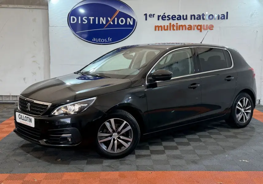 Peugeot 308 Puretech noir vue de 3/4 avant droit, avec phares allumés et jantes alliage distinctives.