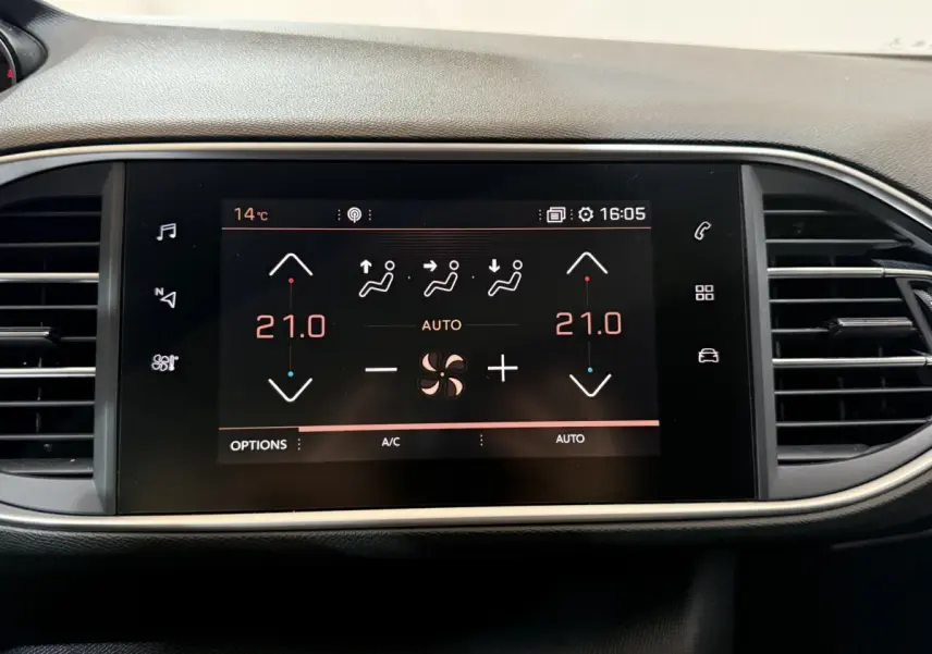 Écran tactile central affichant la climatisation à 21°C sur Peugeot 308 noir, vue frontale du tableau de bord.