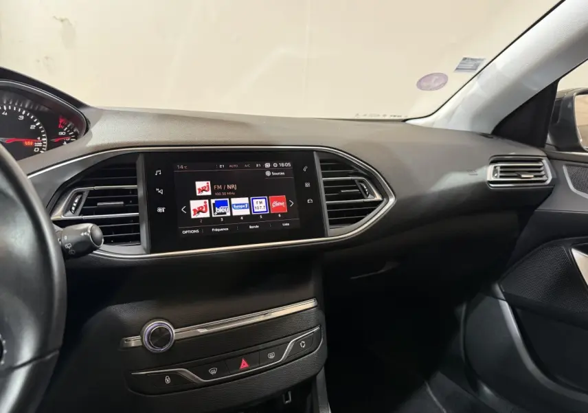 Tableau de bord noir de Peugeot 308 Puretech 130 vu côté passager avec écran tactile central allumé