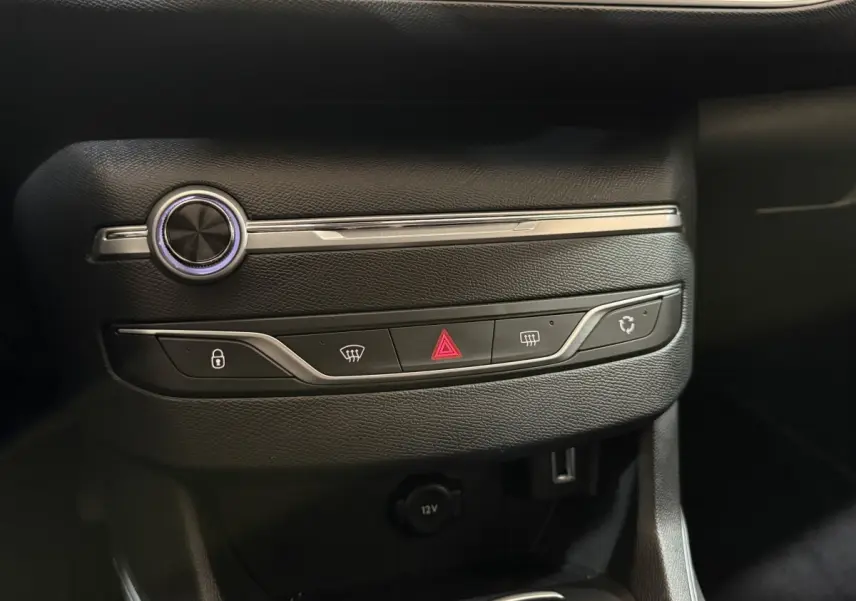 Gros plan sur la console centrale noire de la Peugeot 308 Puretech 130, avec boutons de verrouillage et hazard visibles.