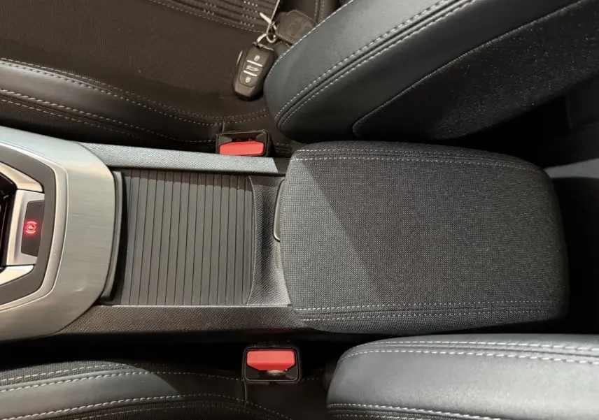 Vue rapprochée de la console centrale noire et des sièges tissu et cuir d'une Peugeot 308 Puretech 130 Allure 2020.