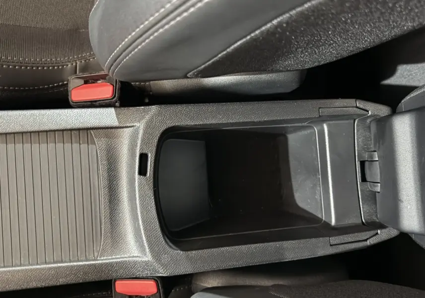 Vue plongeante sur le rangement central noir entre les sièges avant d'une Peugeot 308 Allure 2020.