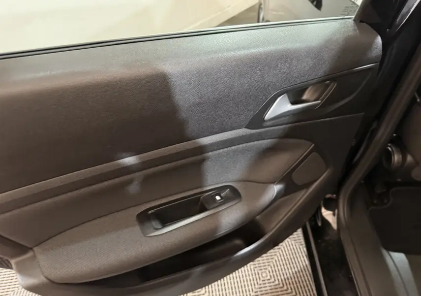 Gros plan sur la porte arrière droite noire de la Peugeot 308 2020, avec poignée intérieure et commande de vitre visible.