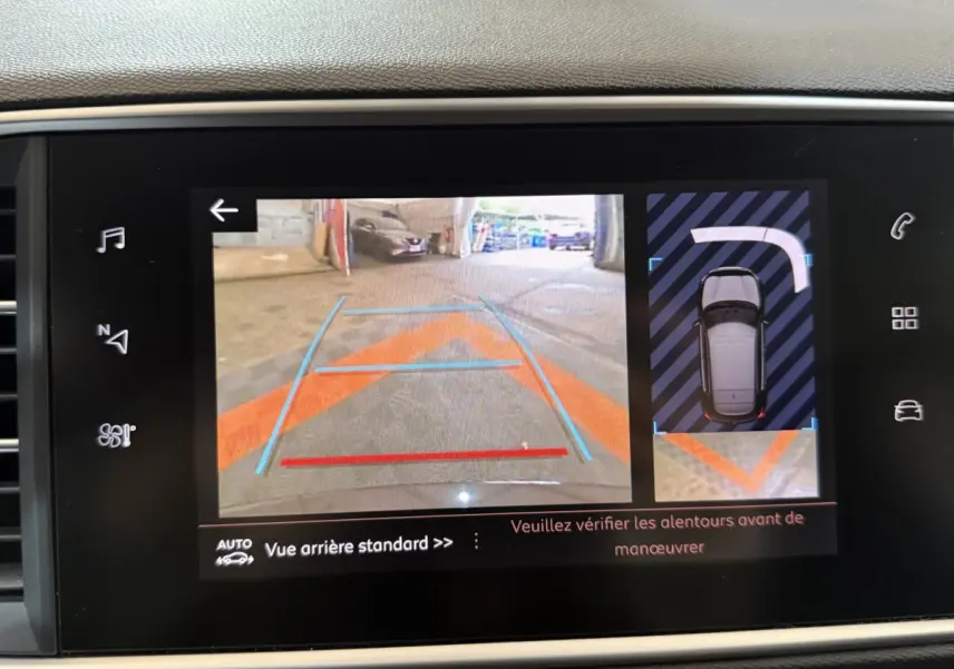 Affichage écran tactile montrant la caméra de recul et l'aide au stationnement du tableau de bord Peugeot 308 noir.