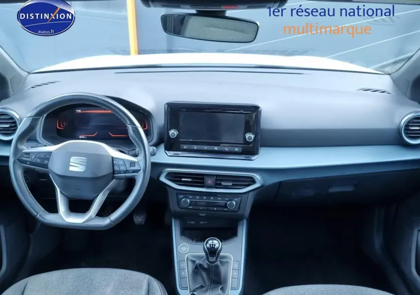 Vue intérieure frontale du tableau de bord et volant cuir multifonction de la SEAT Arona blanche 2023, boîte manuelle.