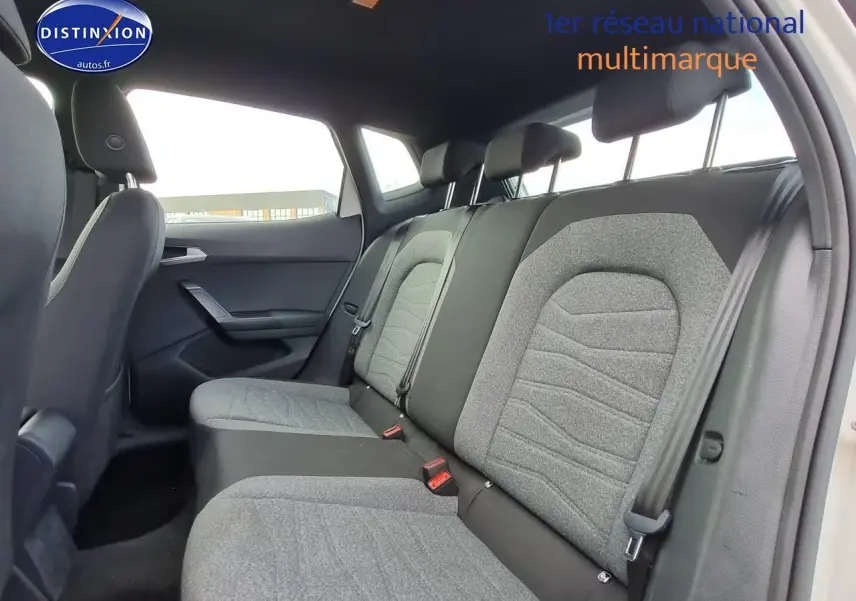 Vue intérieure côté droit montrant la banquette arrière grise et noire du SEAT Arona blanc 2023.