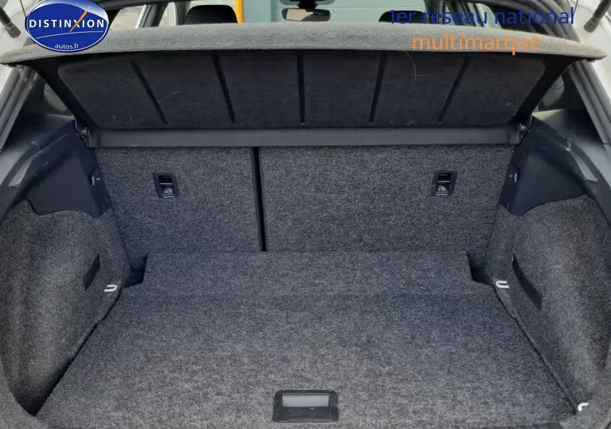 Coffre ouvert vu de l'arrière d'un SEAT Arona blanc 2023, montrant l'espace de chargement et la tablette cache-bagages.