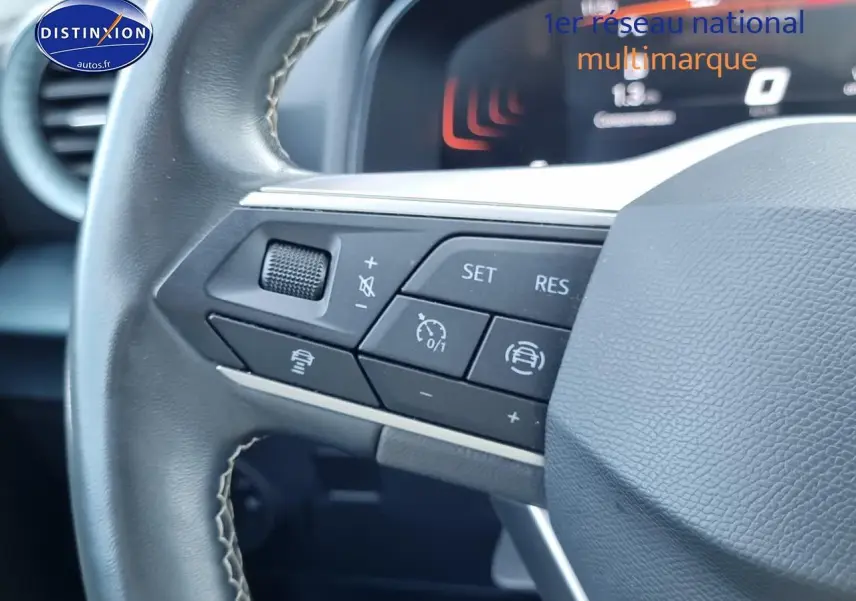 Gros plan sur les commandes multifonctions du volant cuir noir de la SEAT Arona 2023, version essence.