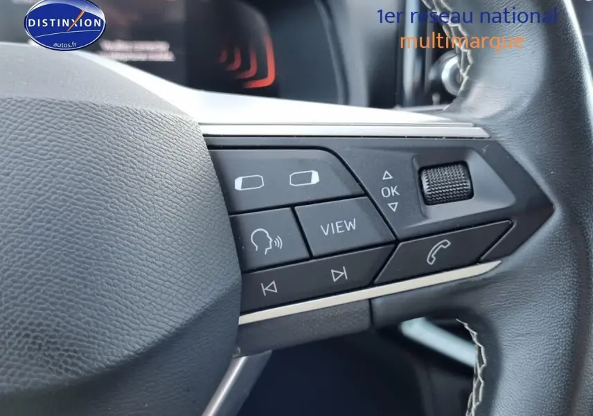 Gros plan sur les commandes multifonctions noires du volant cuir du SEAT Arona blanc, version 2023.