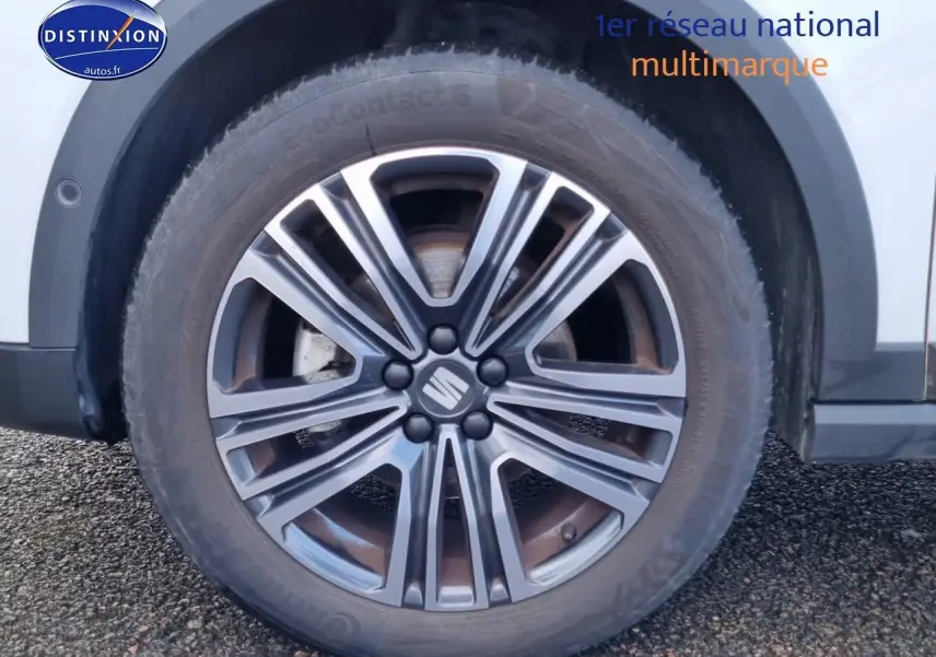 Gros plan sur la jante alu 17 pouces gris foncé du côté droit d’un SEAT Arona blanc 2023.