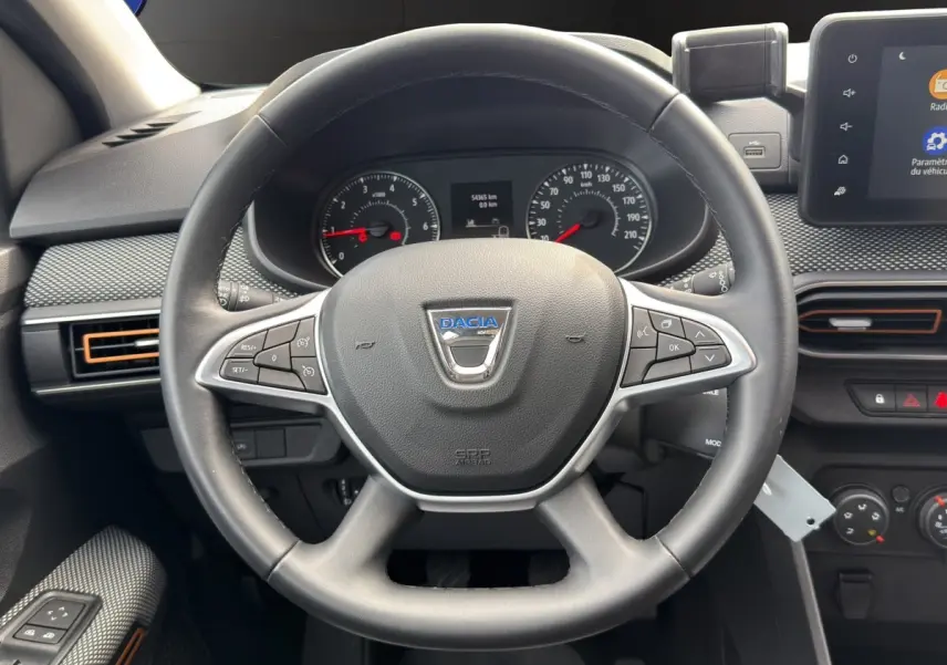 Vue rapprochée du volant cuir noir avec commandes multifonctions du tableau de bord de la Dacia Sandero Stepway blanche 2022.