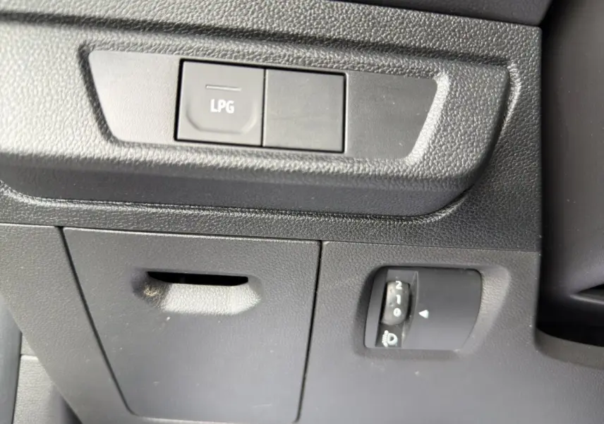 Gros plan sur le tableau de bord côté conducteur de la Dacia Sandero Stepway blanc, bouton LPG et réglage phare visible.
