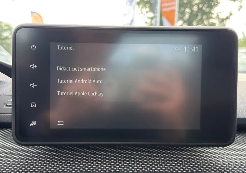 Écran tactile central affichant un tutoriel smartphone dans l’habitacle d’une Dacia Sandero Stepway blanche.
