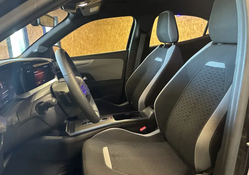 Intérieur de l’Opel Mokka 2025 noir, vue côté gauche sur les sièges avant et le tableau de bord numérique.