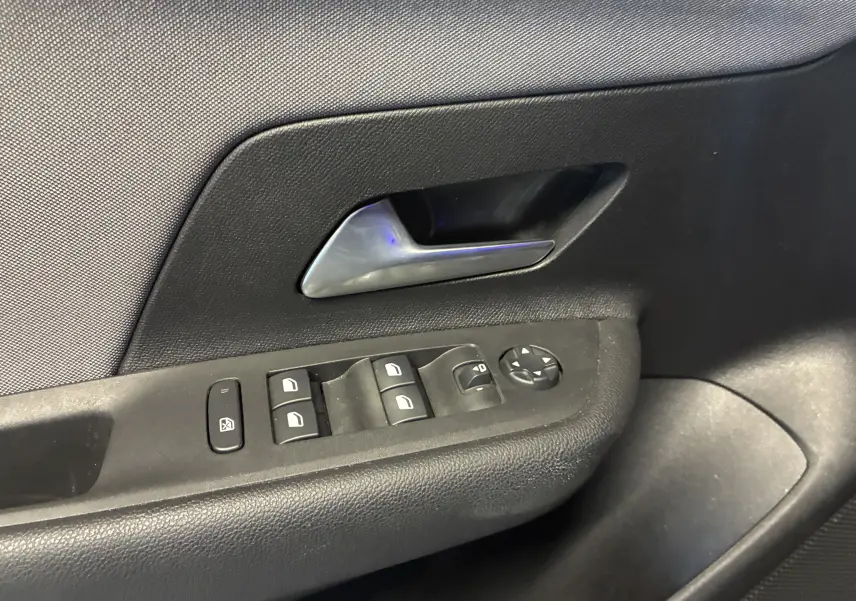 Gros plan sur la poignée intérieure et les commandes de lève-vitres côté conducteur de l’Opel Mokka noir 2025.