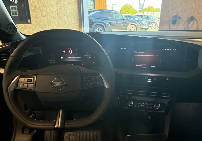 Vue intérieure du poste de conduite de l'Opel Mokka noir 2025, avec tableau de bord numérique et écran tactile central.