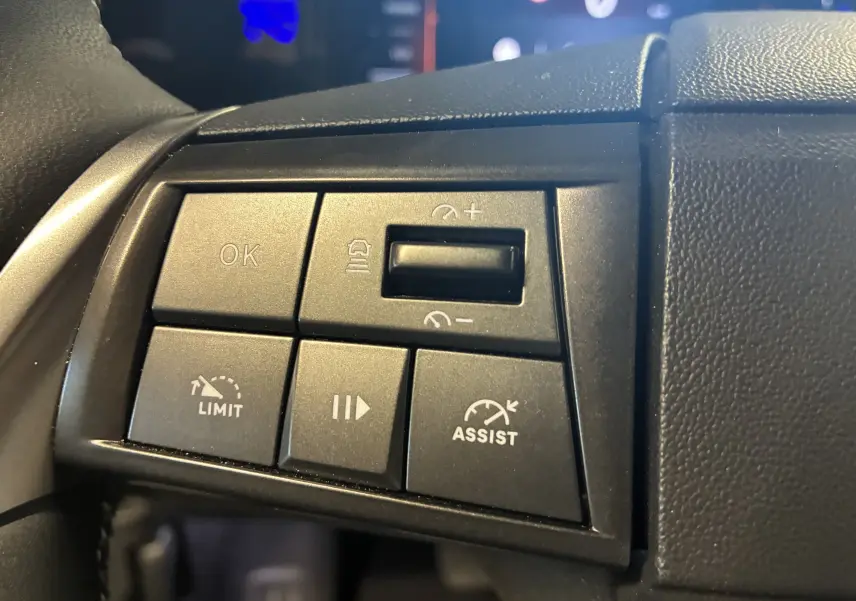 Gros plan sur les boutons de commande au volant de l’Opel Mokka noir 2025, avec régulateur de vitesse et assistant visible.