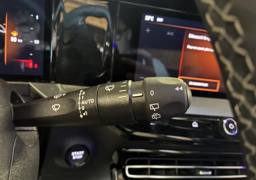 Gros plan sur la commande d’essuie-glace à gauche du volant dans l’habitacle noir de l’Opel Mokka 2025.