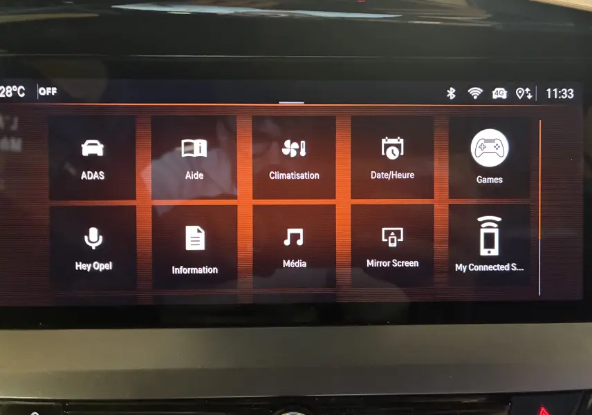 Écran tactile central de l'Opel Mokka 2025 noir, affichant le menu principal avec options connectées et climatisation.
