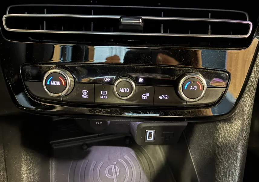 Vue rapprochée de la console centrale noire de l’Opel Mokka 2025, avec commandes de climatisation et port USB visibles.