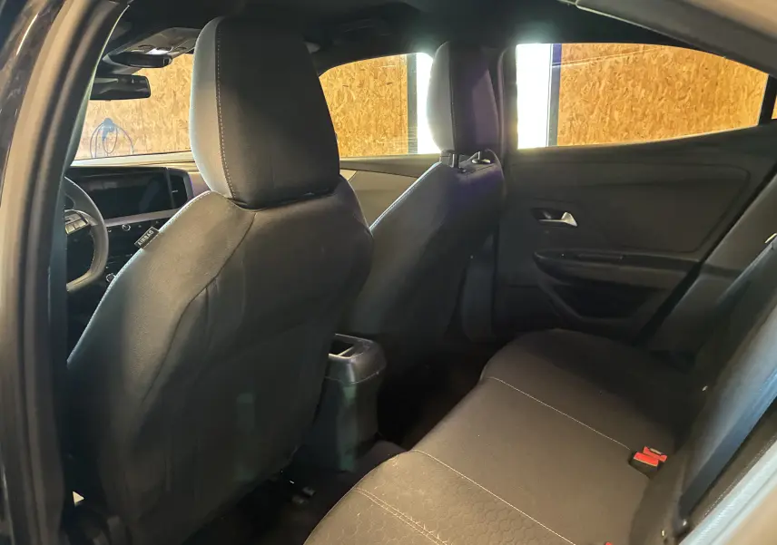 Vue intérieure arrière côté gauche de l’Opel Mokka 2025 noire, montrant les sièges et la partie arrière du tableau de bord.