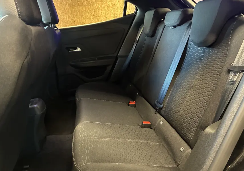 Vue intérieure côté droit des sièges arrière noirs de l'Opel Mokka 1.2 Turbo Hybrid 2025 avec ceinture de sécurité visible.