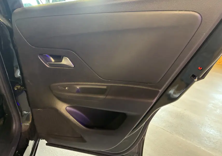 Vue intérieure de la porte arrière gauche noire de l'Opel Mokka 2025, version hybride avec poignée et commandes intégrées.
