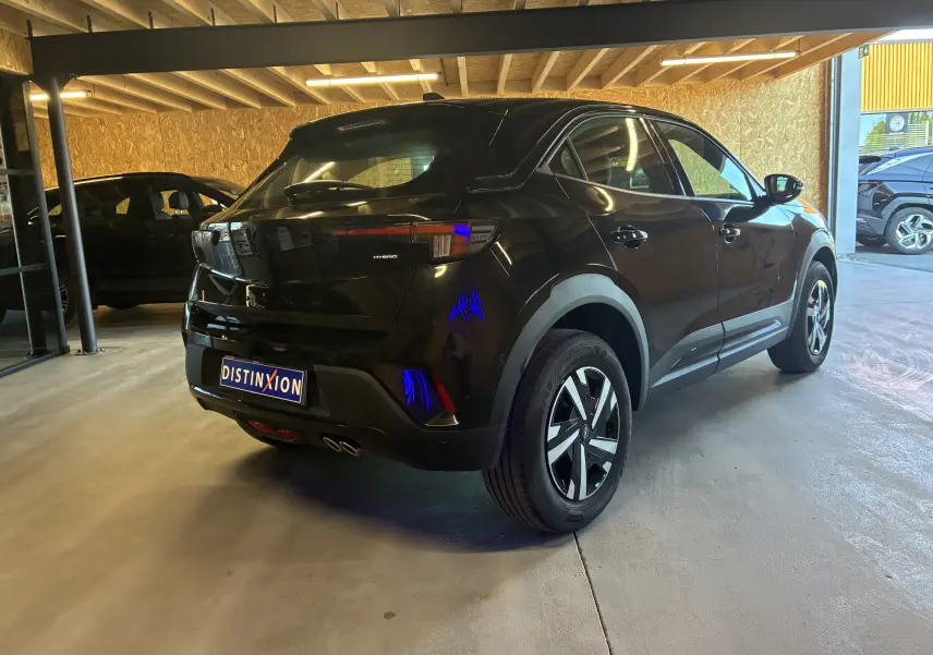 Opel Mokka 1.2 Turbo Hybrid noir vue 3/4 arrière droit, avec feux arrière LED et double sortie d’échappement visible.