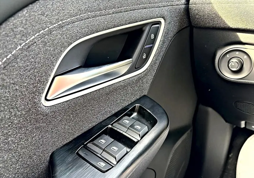 Gros plan sur la commande des vitres et poignée intérieure côté gauche du MG Motor ZS Cosmic Silver 2026.