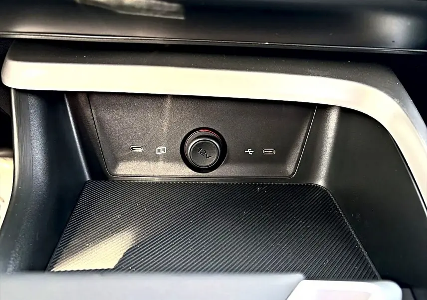Gros plan sur la console centrale noire du MG Motor ZS 1.5 hybrid 197 avec prise 12V et ports USB visibles.