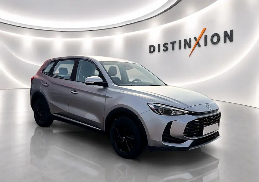 Vue 3/4 avant du SUV MG ZS Cosmic Silver 2026 avec jantes noires, dans un showroom lumineux moderne.