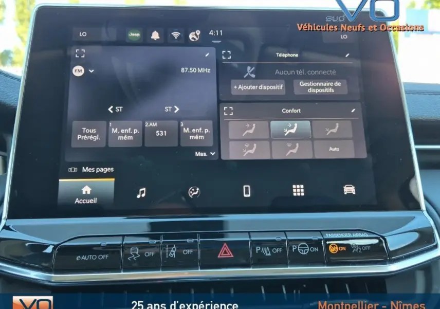 Écran tactile central du Jeep Compass gris 2024 montrant les réglages radio et climatisation automatique