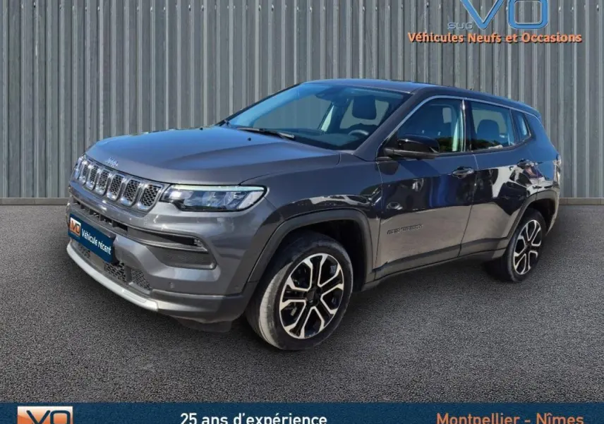 Jeep Compass gris 3/4 avant droit avec jantes alliage 18 pouces, vue extérieure sur fond neutre.