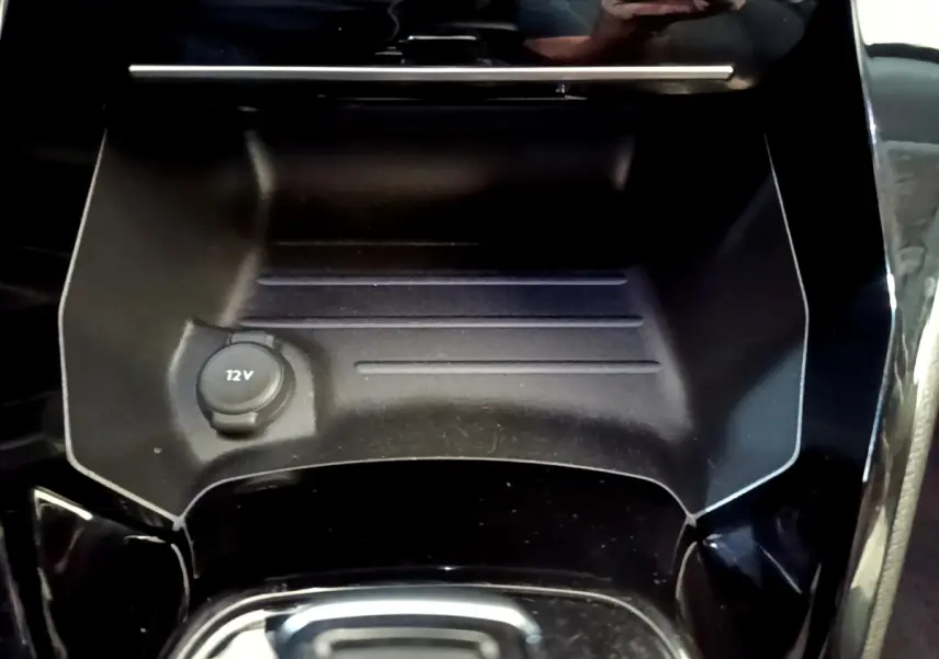 Prise 12V dans le rangement central avant noir brillant d'un Peugeot 2008 gris foncé, version 2022.