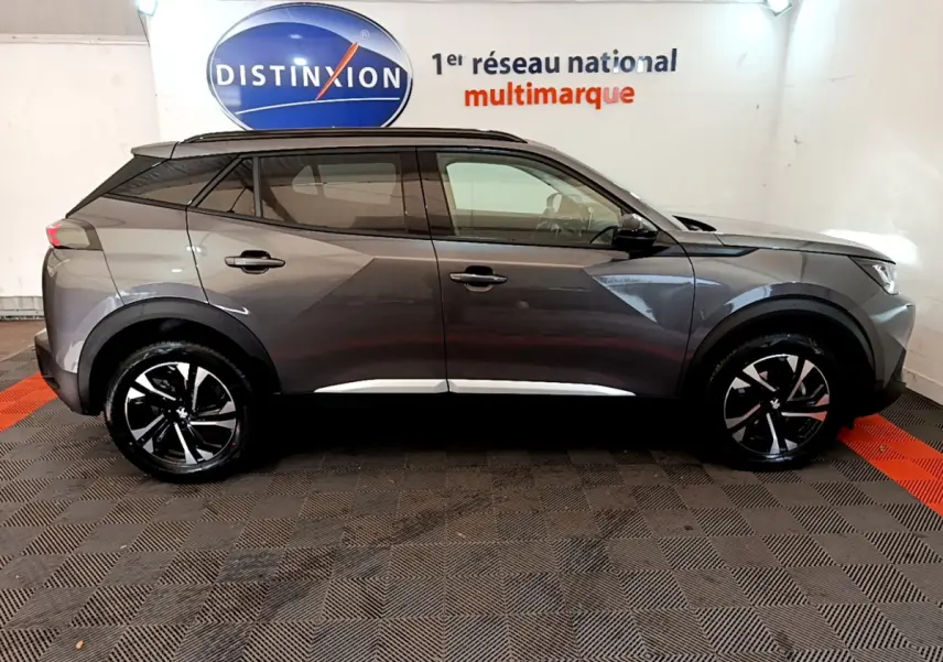 Peugeot 2008 gris foncé vue de profil côté gauche, avec jantes noires et toit noir contrastant.